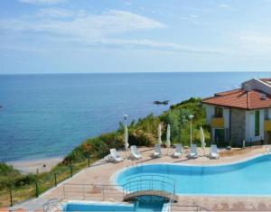 a resort with a swimming pool next to a beach at Family Hotel Lalov Egrek in Lozenets