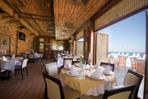 Hotel Lalov Egrek في لوزينيتس: مطعم بطاولات وكراسي ونافذة كبيرة