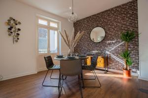 a dining room with a brick wall and a table and chairs at Le Canal,Hyper centre, Cosy, fibre, parking privée, 1 a 4 pers in Montargis