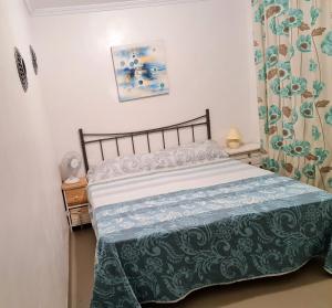 1 dormitorio con 1 cama con edredón verde y blanco en Cómodo apartamento cerca del mar en Santa Pola