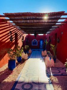 um corredor com um edifício vermelho com cadeiras e um tecto em Le Relais De Marrakech em Marrakech