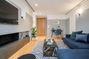 uma sala de estar com um sofá azul e uma lareira em Kula London - Holborn em Londres