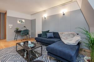 ein Wohnzimmer mit einem blauen Sofa und einem Glastisch in der Unterkunft Kula London - Holborn in London