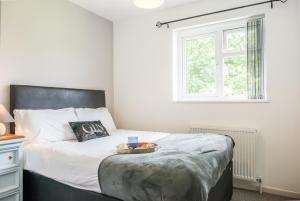 Un dormitorio con una cama con una bandeja de comida. en Comfy 3-Bed House near City Centre, sleeps 6, en Tile Hill