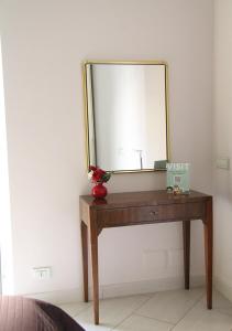 uno specchio sopra un tavolo in legno in una stanza di Soraya a Napoli