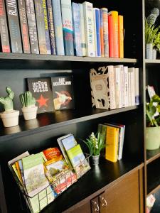 a book shelf filled with books and potted plants at Großes Ferienzimmer Uckermark in Casekow