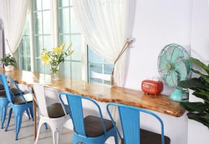 a dining room with a wooden table and blue chairs at 小逗民宿 in Taitung City