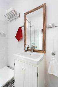 een badkamer met een witte wastafel en een spiegel bij Casa tradicional Canaria en La Laguna centro in La Laguna