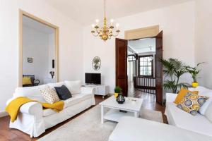a living room with white furniture and a chandelier at Casa tradicional Canaria en La Laguna centro in La Laguna