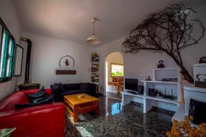 ein Wohnzimmer mit einem roten Sofa und einem Tisch in der Unterkunft Casa Chalet La Casita in Tabayesco