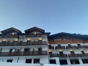 a white building with balconies on the side of it at Hotel Pizboè in Mazzin
