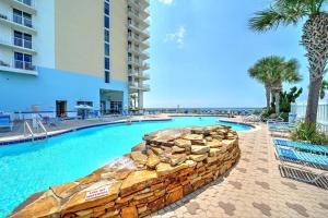 Una piscina con palmeras y un edificio. en Majestic Beach Resort Tower 2 by Panhandle Getaways, en Panama City Beach