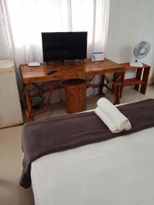 escritorio con ordenador encima de la cama en Studio em Arraial, en Arraial do Cabo