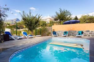 uma piscina com cadeiras e um guarda-sol em Finca La Casita en entorno natural em Arafo