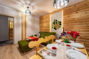 a living room with a table and a green couch at Sauna-balia-Apartamenty Góraleczka II- w wakacje w każdą środę i czwartek gorąca balia GRATIS in Czarna Góra