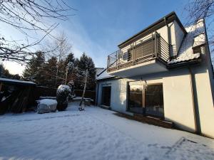 Casa con balcón y patio cubierto de nieve en Nowy Dom Apartament z Widokiem na Góry 8 osób en Bielsko-Biala