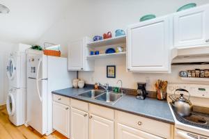 a kitchen with white cabinets and a sink and a refrigerator at Day Dreamer in Florence +6 photos