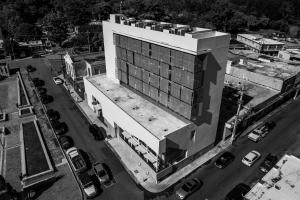 un grande edificio con auto parcheggiate in un parcheggio di Royal Delonix a Penuelas