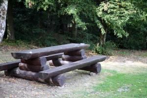 a bench made out of logs in a park at Pension U Štěpánků in Trpišovice