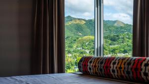 a window with a view of a mountain at Royal Delonix in Penuelas