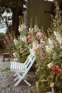 a white bench sitting in a garden of flowers at Axatorpsgården in Trelleborg