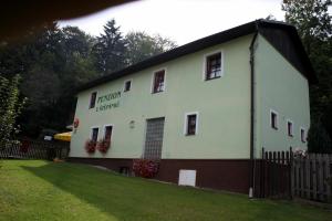 a white building with a fence in a yard at Pension U Štěpánků in Trpišovice