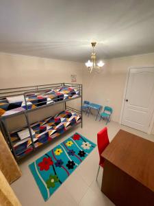 a bedroom with a bunk bed with a table and chairs at Kotorosl Hotel in Yaroslavl