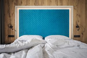 a bed with a blue headboard in a bedroom at Appartement Zillertal Klee mit Restaurant KleemenTine in Ried im Zillertal