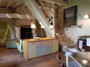 a kitchen with a counter and a table in a room at Romantic Mill Cottage 30 min from Bergerac France in Sourzac