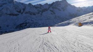 Eine Person fährt einen schneebedeckten Berg hinunter in der Unterkunft Margherita sulla neve - trilo 200 m from slopes in Passo del Tonale