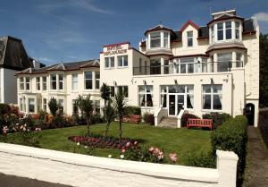 a large white house with a garden in front of it at SGE Esplanade Hotel in Dunoon