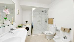 Un baño con lavabo, inodoro y ducha. en Vistas al Teide II Piscina climatizada 39, en Puerto de la Cruz 23 fotos más