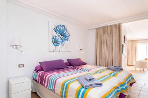 Un dormitorio con una cama grande con toallas. en Vistas al Teide II Piscina climatizada 39, en Puerto de la Cruz