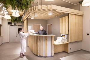 a woman standing at a counter in a room with a man at Les Balcons Platinium Val Cenis in Lanslevillard +37 photos