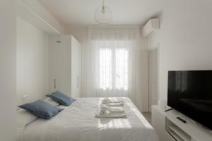 a white bedroom with a bed and a television at Amazing terrace in Milan- Città Studi in Milan