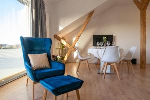 a dining room with a blue chair and a table at Landhaus Wiesenblick in Zarrendorf +56 photos