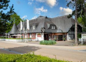 a building with a gambrel roof on a street at Landhaus Carstens in Timmendorfer Strand