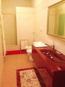 a bathroom with a sink and a toilet and a mirror at La Casa di Amici Miei in Cremona