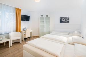 ein Hotelzimmer mit zwei Betten und einem Schreibtisch in der Unterkunft Stadt-gut-Hotel Rheinischer Hof in Essen