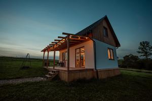 ein kleines Haus inmitten eines Feldes in der Unterkunft Pastelova Krova - domki w Bieszczadach in Ustrzyki Dolne