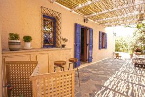 un porche de una casa con una puerta azul en Villa Oleander, en Spetses