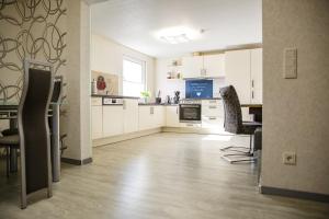 a kitchen with white cabinets and a table and chairs at Ferienwohnung Ogger in Bad Salzungen