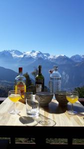 a table with wine glasses and bottles of wine at Vue exceptionnelle ALPE D HUEZ in LʼHuez