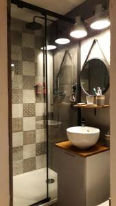 a bathroom with a glass shower with a sink and a mirror at Vue exceptionnelle ALPE D HUEZ in LʼHuez