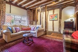 a living room with two couches and a table at Extraordinary 15th Century timber framed cottage in famous Medieval village - The Tryst in Lavenham