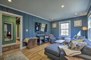 a living room with blue walls and a blue couch at Renovated Carrboro House with Deck and Fire Pit! in Carrboro