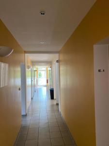 un couloir vide menant à une chambre dans l'établissement Arbeiterwohnheim Workers Dormitory Graz, à Graz