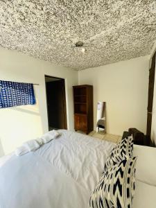 a bedroom with a white bed and a ceiling at Casa ELA in Antigua Guatemala