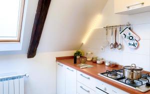 a kitchen with white cabinets and a stove top oven at Apartment Mletačka in Zagreb