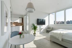 een witte slaapkamer met een wit bed en een tafel bij Sophienne Apartments in Wenen